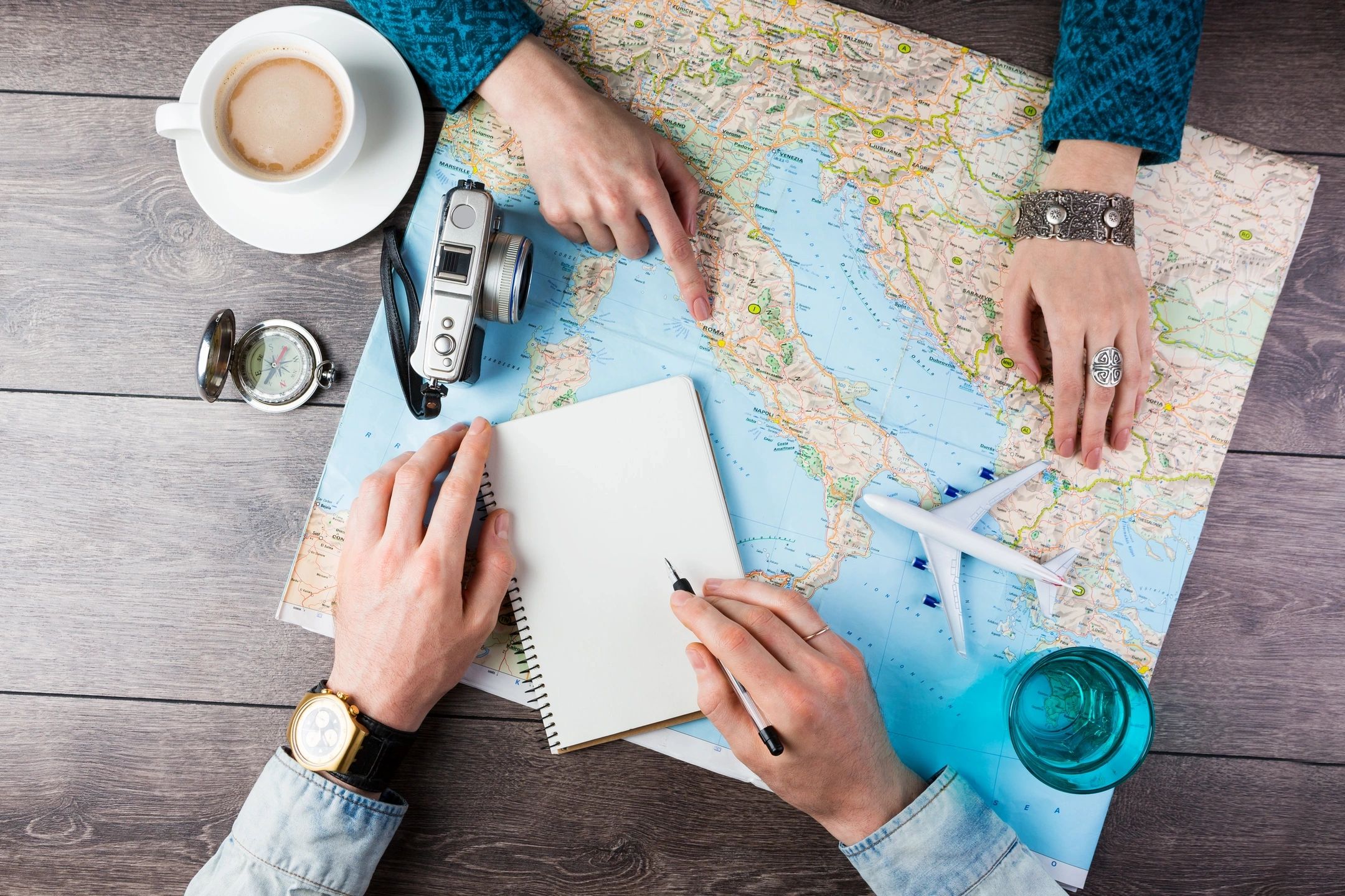 Hands planning trip on map with toy plane